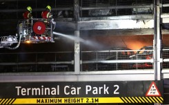 Firemen battle a fire at London's Luton Airport which caused a partial collapse of a parking structure