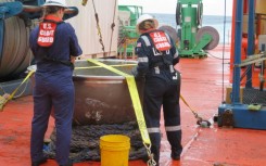 US Coast Guard engineers survey the recovered titanium endcap of the Titan sumbersible on October 1, 2023