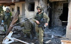 Israeli soldiers cordon off an area in Kibbutz Beeri near the border with the Gaza Strip on October 15, 2023, more than a week after the attack by Palestinian militants