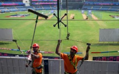 Point of view: Workers clean glass outside the media box at the Wankhede Stadium in Mumbai on Monday