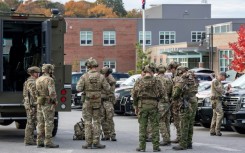 A law enforcement official blocks the road to Schemengees Bar where the shooting took place in Lewiston, Maine