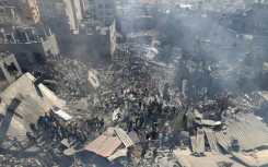 People search for survivors and the bodies of victims through the rubble of buildings destroyed during Israeli bombardment, in Khan Yunis in the southern Gaza Strip on October 26, 2023