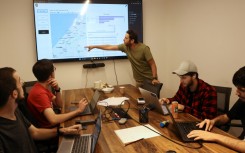 Tech industry volunteers analyse data on missing hostages at an office in Tel Aviv