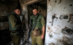 Israeli soldiers enter a home in Kfar Aza, one of the kibbutzim attacked by Palestinian Hamas militants on October 7