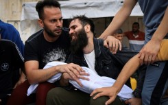 A father mourns his child killed in an Israeli strike on Khan Yunis in the southern Gaza Strip, before his burial on October 29, 2023