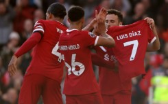 Liverpool forward Diogo Jota shows off a shirt with the name of forward Luis Diaz