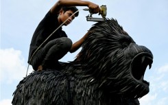 A worker fixes a King Kong statue made with old tyres at artist Mean Tithpheap's house in Cambodia