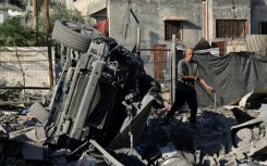 A Palestinian man inspects debris following an Israeli strike in Rafah in the southern Gaza Strip