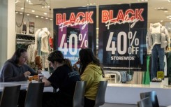 A family eats lunch near a store advertising a Black Friday sale at the Pentagon City Mall in Arlington, Virginia