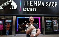 HMV owner Doug Putman holds his dog Ollie outside Oxford Street's famed store