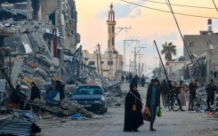 People walk along a street in the Khezaa district on the outskirts of the southern Gaza Strip city of Khan Yunis