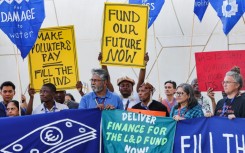 Environmental activists display placards during a demonstration at the venue of the COP28 United Nations climate summit in Dubai 