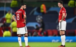 Bruno Fernandes and Jonny Evans look on after Manchester United were eliminated from the Champions League