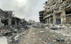 Palestinians walk along destroyed streets in Gaza City