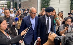 Singaporean transport minister S. Iswaran (centre L) leaves court after an appearance on Thursday