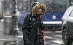 A woman walks as snow falls during a storm in New York City on January 19, 2024, but several parts of the country were getting pummelled by blizzard conditions