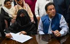 Imran Khan and his veiled wife Bushra Bibi signing court documents in Lahore last year. A judge ruled on Saturday that their marriage was illegal