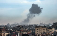 A plume of smoke is seen rising over Khan Yunis from nearby Rafah in the southern Gaza Strip