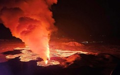 Live video images showed glowing lava oozing out of a fissure illuminating a plume of smoke rising up under the night sky