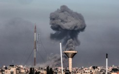 This picture taken from Rafah, in the southern Gaza Strip, shows smoke rising over buildings in Khan Yunis during Israeli bombardment on February 8, 2024