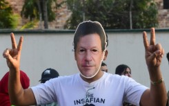 A man wearing a mask of jailed former Pakistan prime minister Imran Khan protests against alleged election rigging in Karachi 