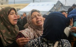 Palestinian women mourn the death of relatives in an Israeli air strike in Gaza's Deir al-Balah 