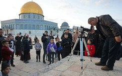 A man uses a telescope to look for the moon to mark the start of the Muslim holy month of Ramadan near the Dome of the Rock in Jerusalem