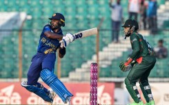 Sri Lanka's Janith Liyanage plays a shot as Bangladesh's Mushfiqur Rahim (R) watches during the first one-day international