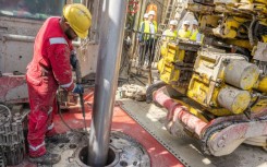 A worker operates a drill at a geothermal plant construction site in south Germany