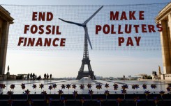 Activists demonstrate in Paris against fossil finance, with the Eiffel Tower in background, on June 21, 2023