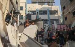 Palestinians search for casualties in the rubble of a house destroyed in an Israeli strike on Rafah, in the southern Gaza Strip