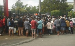 People queue outside a supermarket in New Caledonia's Noumea