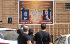 Portraits of Iran's President Ebrahim Raisi, on the left, and Foreign Minister Hossein Amir-Abdollahian on a wall in the central Iraqi holy city of Najaf