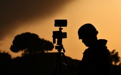 A member of the media stands behind his camera at a spot overlooking the Gaza Strip in the southern Israeli city of Sderot in a file picture taken on October 26, 2023