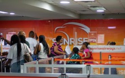 Passengers queue at the Sunrise Airways counter in Haiti's Toussaint Louverture International Airport in Port-au-Prince on May 20, 2024, the first day of commercial flights since the airport closed in March due to gang violence