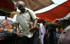 A volunteer distributes water during a hot summer day in Delhi on May 17