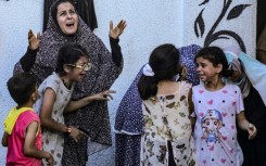 Palestinians react to an Israeli strike on a building in Nuseirat on May 25, 2024