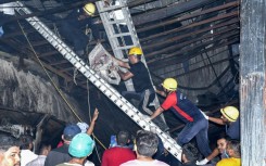 Rescue workers carry a victim after a fire broke out at an amusement park facility in Rajkot, in India's Gujarat state