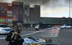 A police officer covers the body of a victim of the Russian strike on a hardware store in Kharkiv, Ukraine, on Saturday