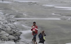 A man carries a child as he walks towards a shelter: cyclones have killed hundreds of thousands of people in Bangladesh in recent decades, but better forecasting and more effective evacuation planning have dramatically reduced the death toll