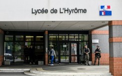 French gendarmes stand guard outside a high school in the western town of Chemille-en-Anjou, where a teacher was stabbed by pupil 