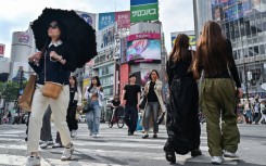 Pedestrians cross the intersection at Shibuya Crossing in Tokyo