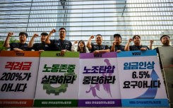 Samsung Electronics' union members hold placards during a rally outside the company building in Seoul 