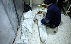 A medical worker covers a body at the hospital in Idlib