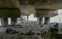 Homeless people are seen resting under a flyover to escape a searing heatwave in New Delhi on May 31