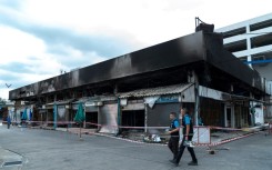 Forensics officers survey the area after a fire at a pet market next to Chatuchak market in Bangkok