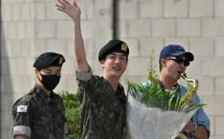 BTS superstar Jin (C) is greeted by bandmates RM (R) and Jimin after being discharged from his mandatory military service