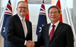 Prime Minister Anthony Albanese (L) shakes hands with Premier Li Qiang, the highest-ranking Chinese official to visit Australia in seven years