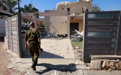 An Israeli soldier checks a house that was hit by a Hezbollah rocket in Kiryat Shmona, northern Israel, near the Lebanon border