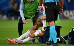 Kylian Mbappe receives medical treatment after breaking his nose during France's 1-0 win against Austria at Euro 2024